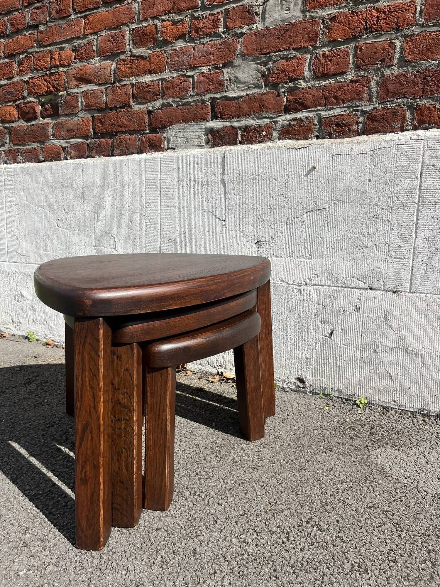 Nested tripod tables made of solid wood, in a modernist brutalist style.