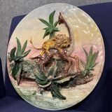 Plat en céramique figurant un lion attaquant une girafe