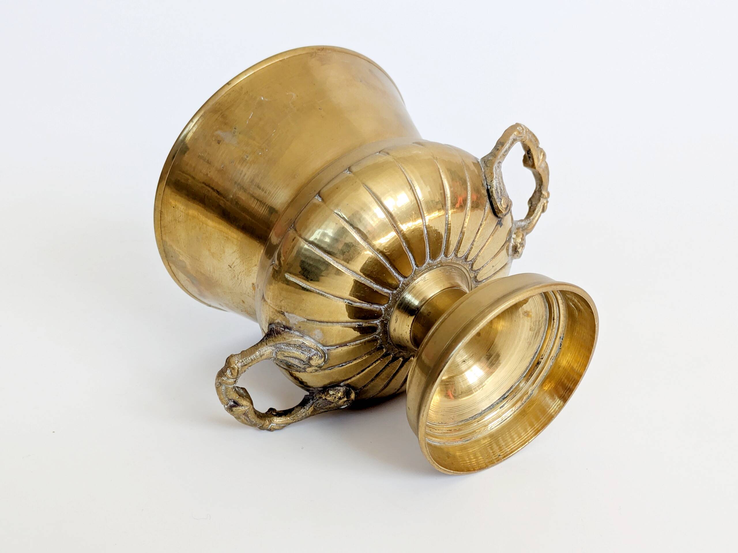 Vintage brass cache-pot on a stand with handles, classic decor.