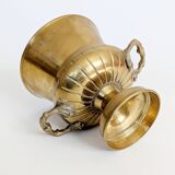 Vintage brass cache-pot on a stand with handles, classic decor.
