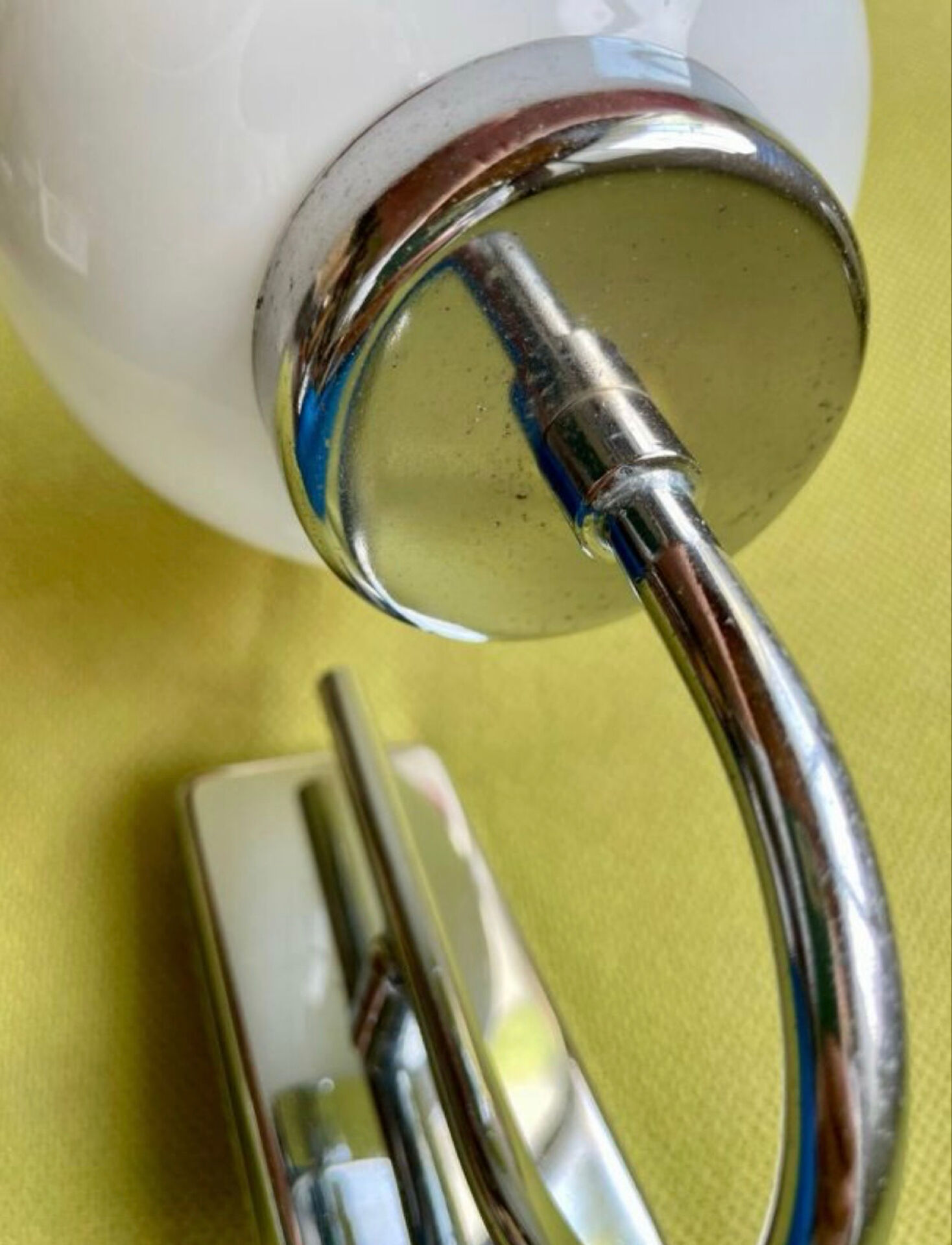 Pair of chrome metal wall lights with white glass globe.
