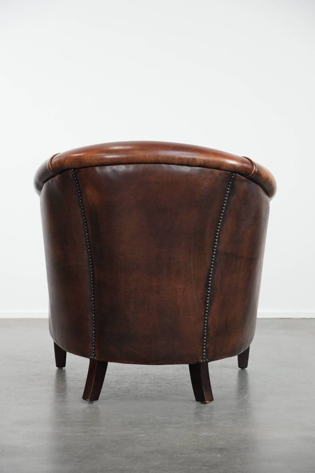 Club chair made of sheepskin leather finished with decorative nails