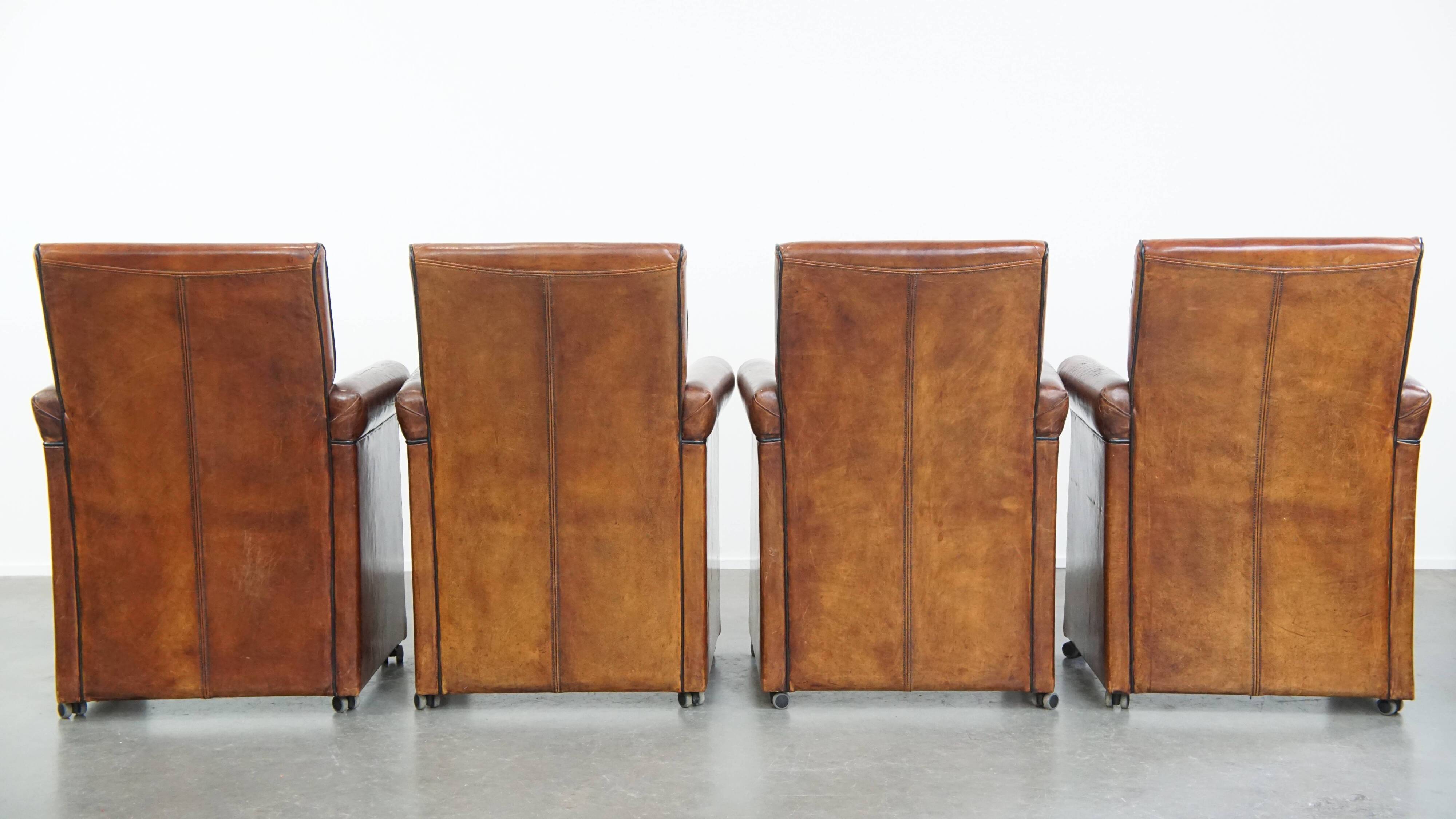 Vintage set of 4 sheepskin leather dining chairs on castors