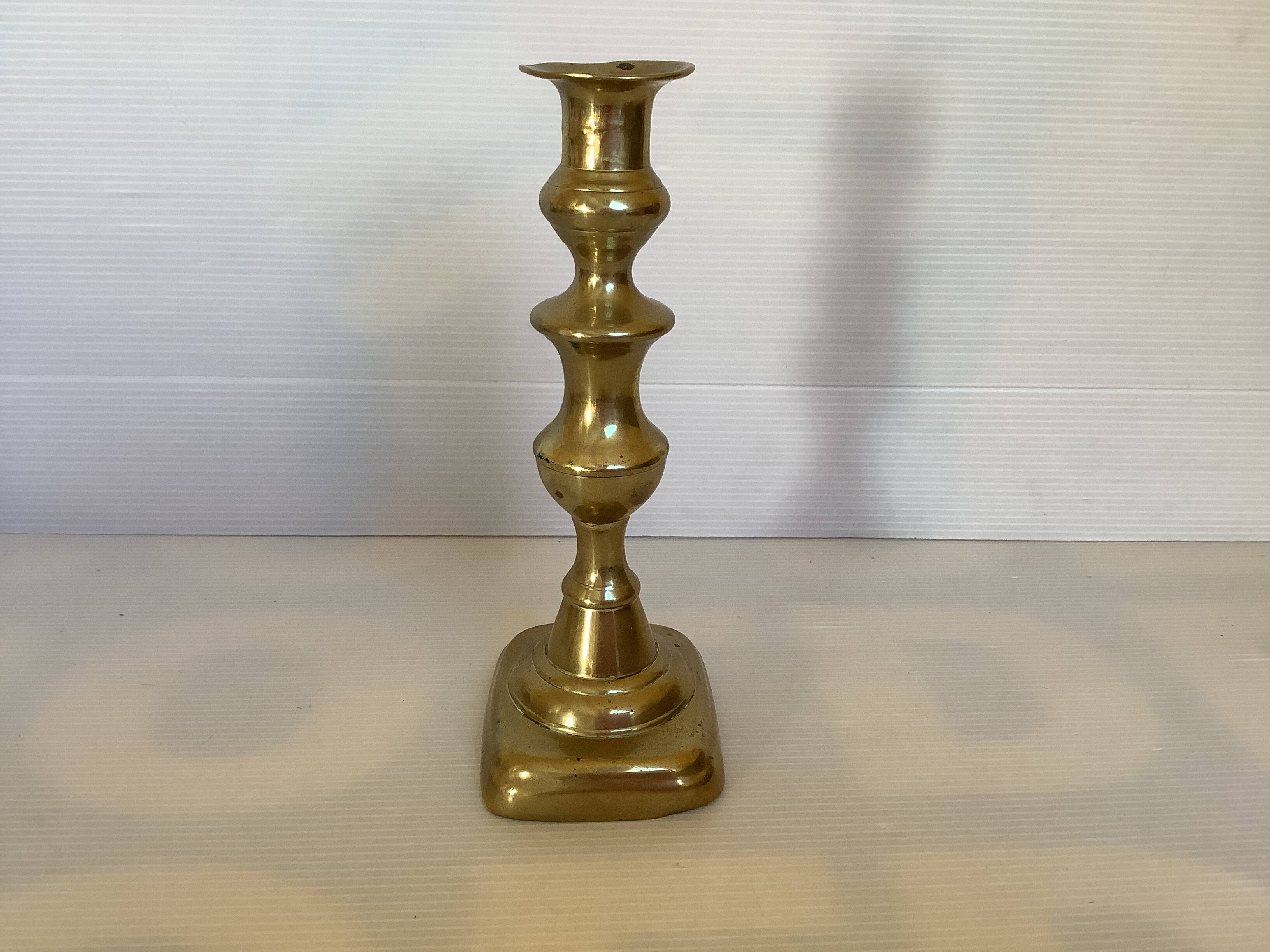 Brass candlestick with a rectangular base.
