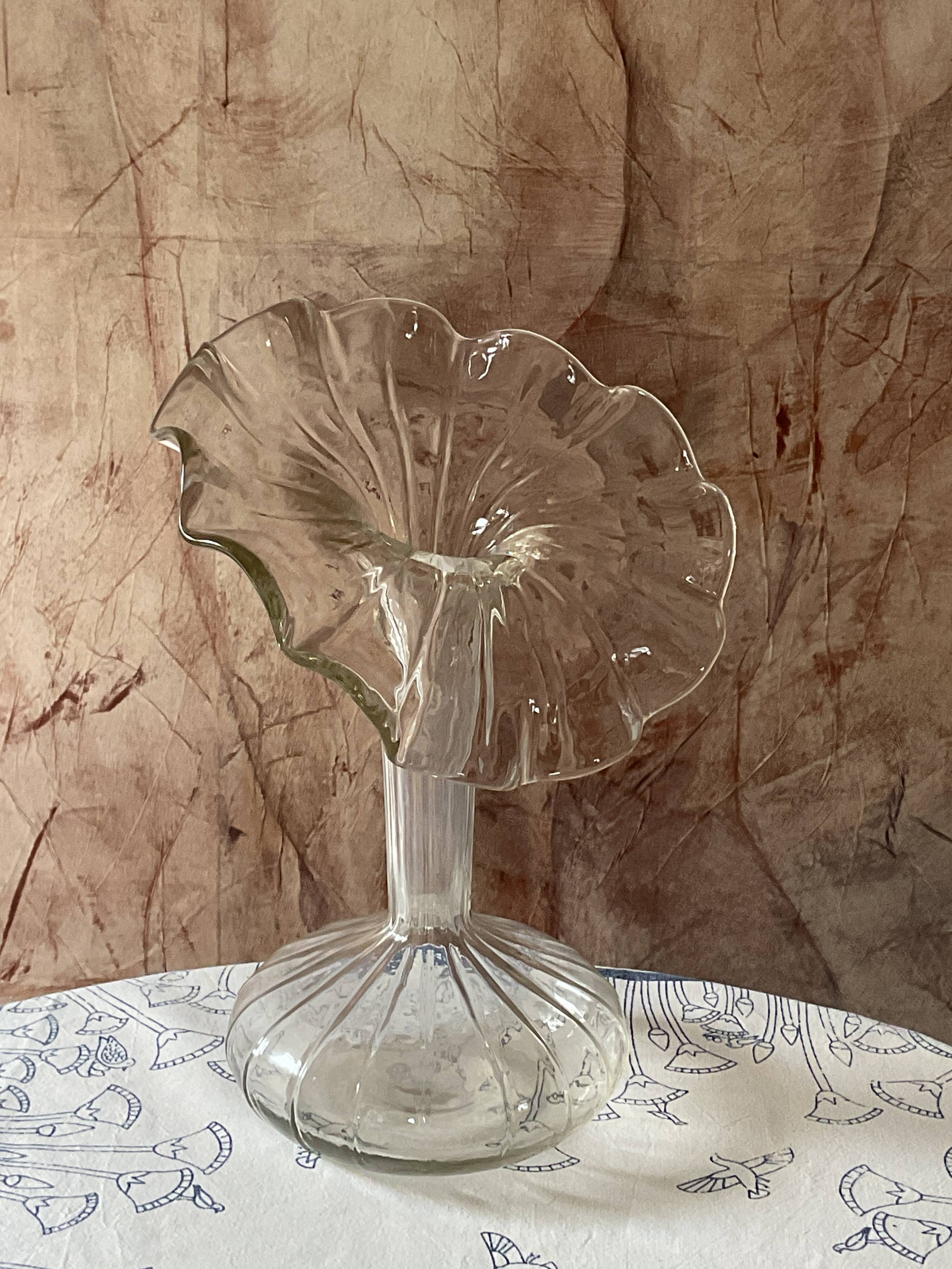 Vintage transparent glass vase in flower shape.