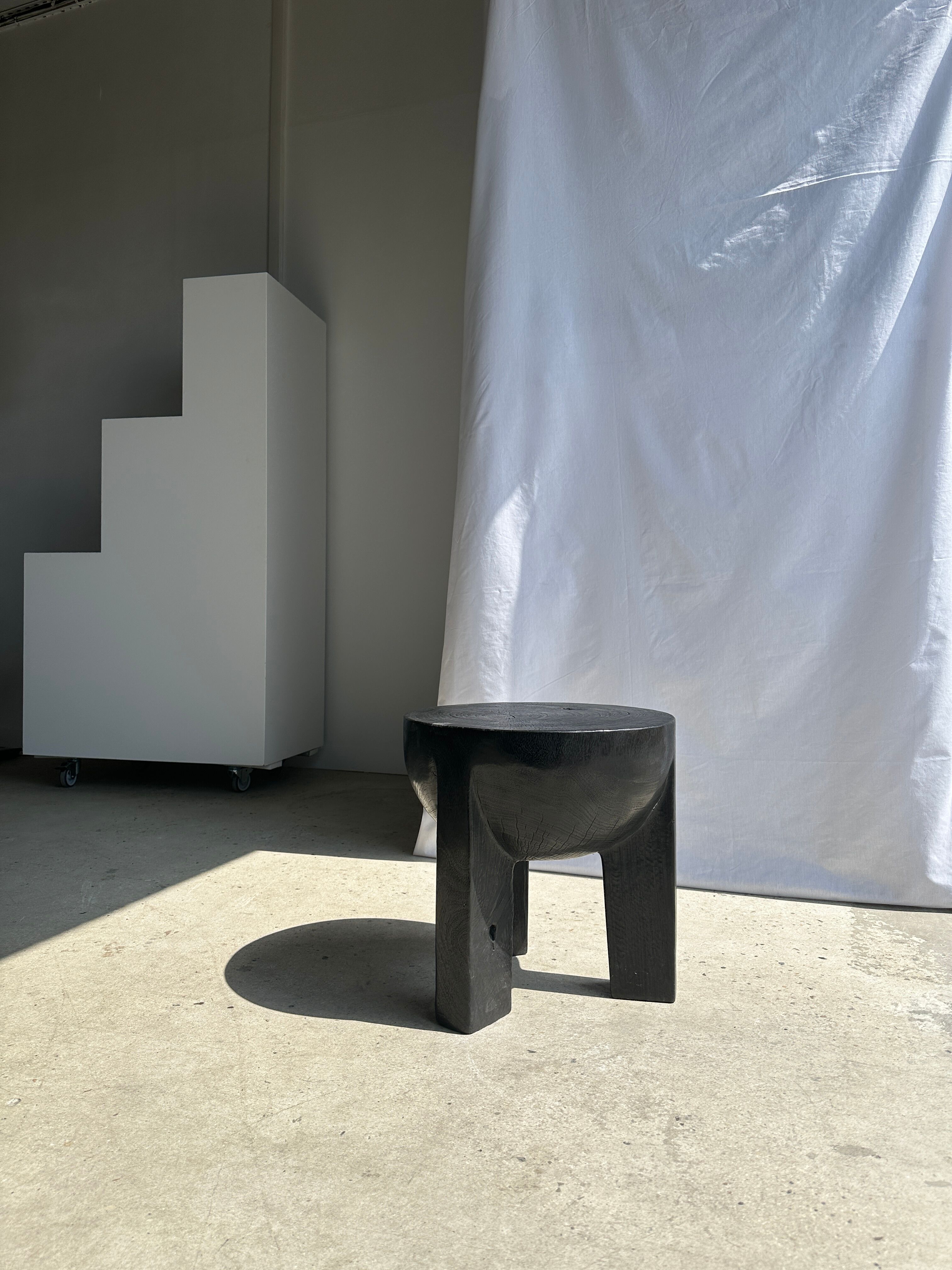 Black mango wood tripod side table with a semi-spherical top, height: 45 cm, diameter: 44 cm.