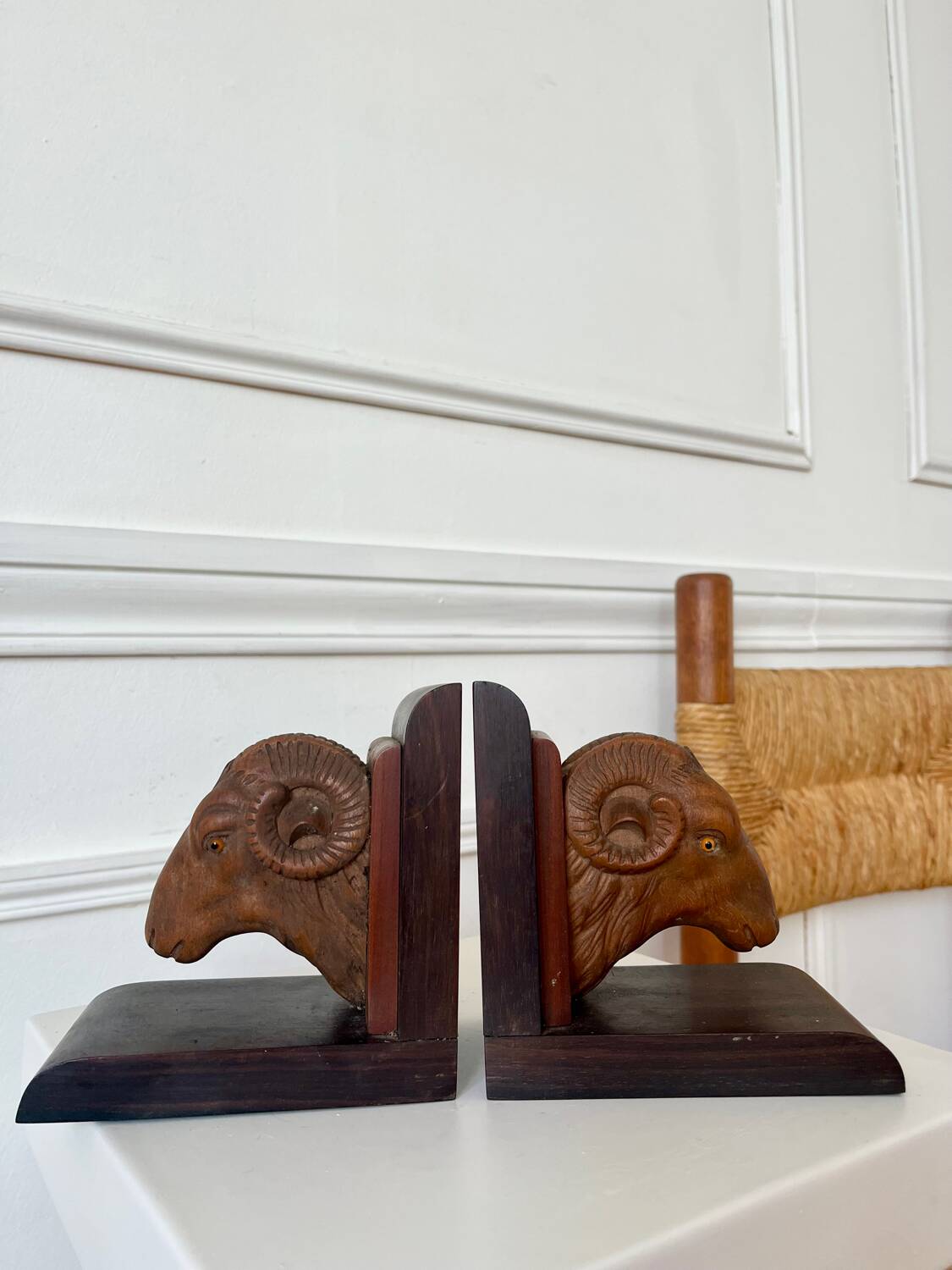 Pair of carved wooden bookends in the shape of ram's heads.