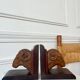 Pair of carved wooden bookends in the shape of ram's heads.