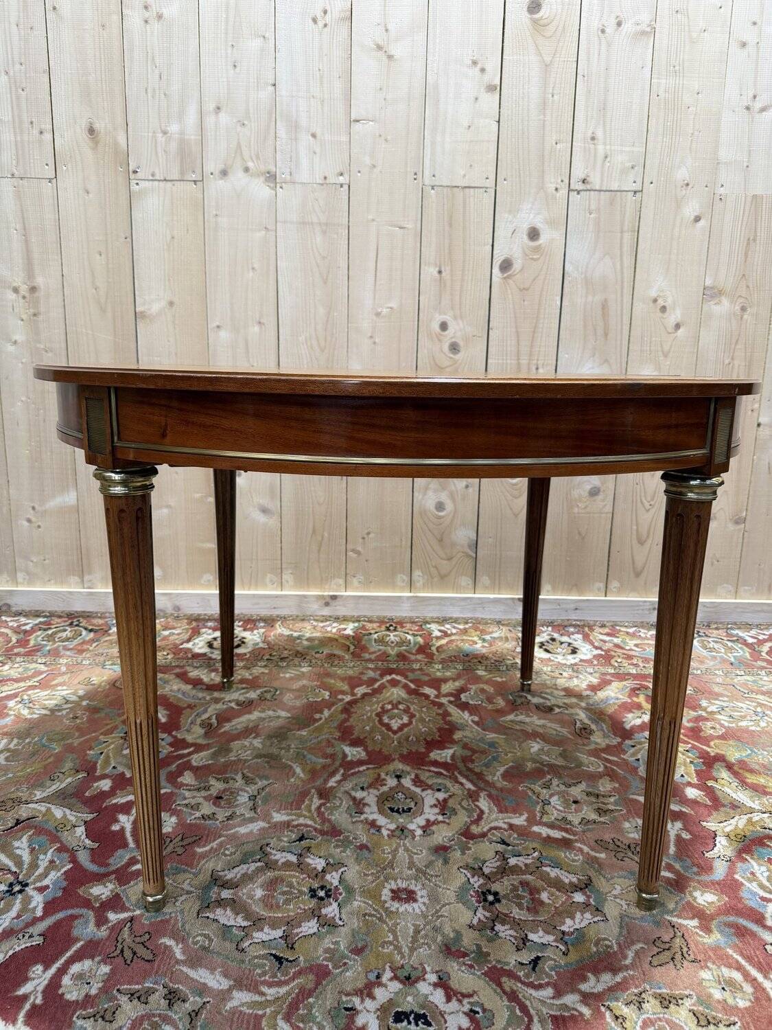 Round dining table with leather top in Louis XVI style.