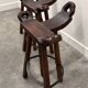 Set of 3 rustic carved oak bar stools with iron footrests, 1970s