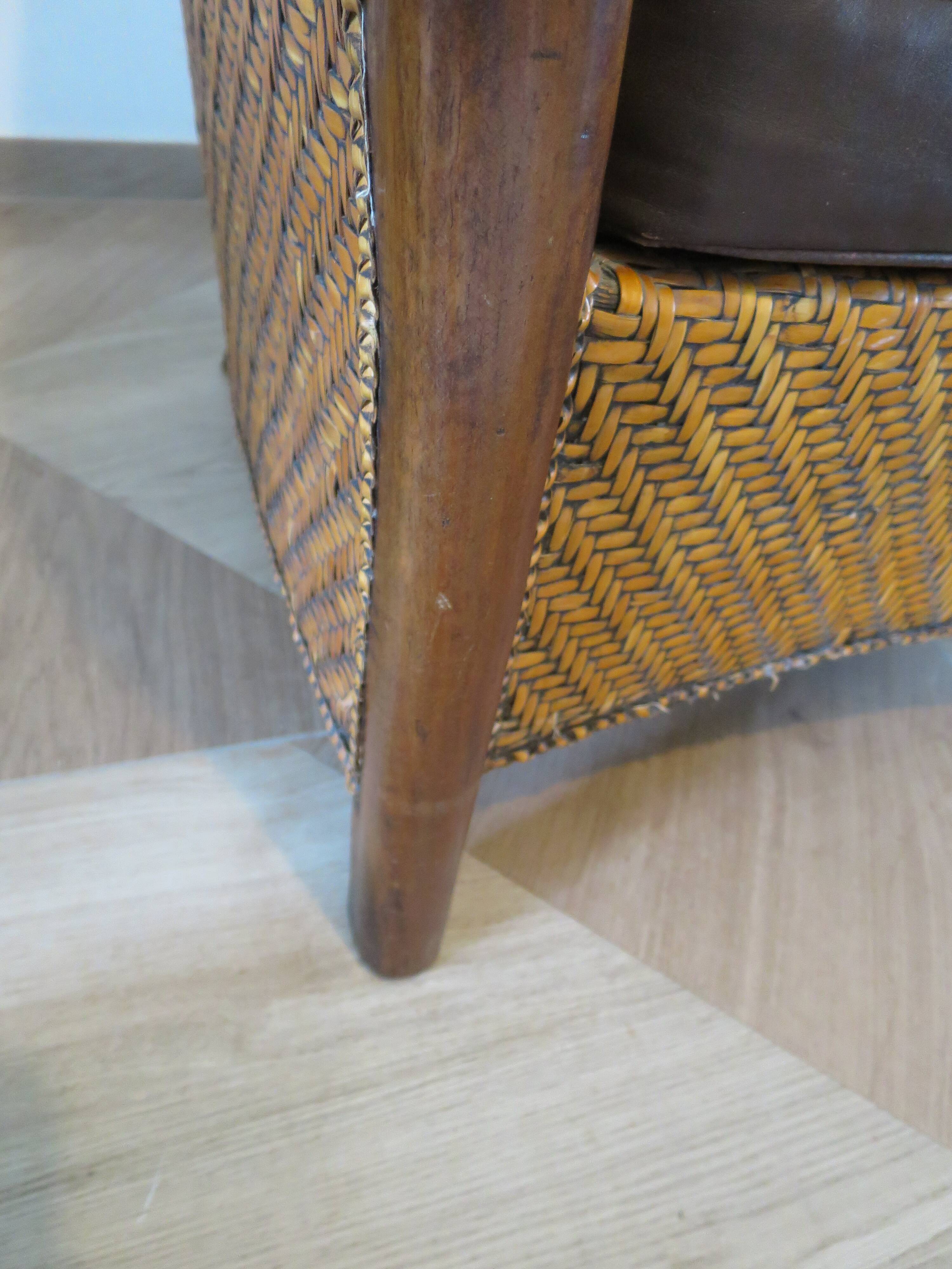 Colonial style armchair in woven rattan and exotic wood