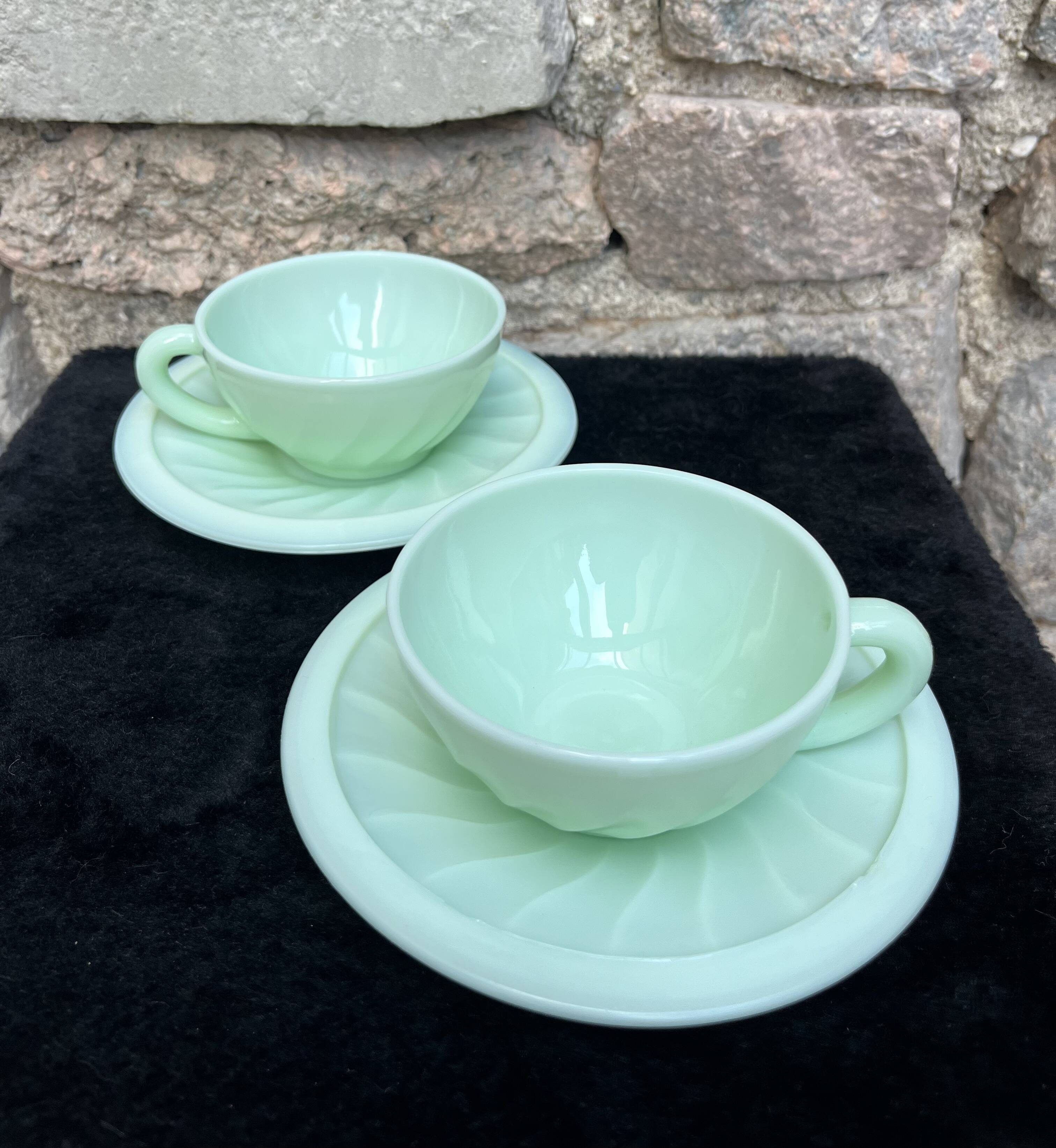 Two green opaline cup and saucer sets.