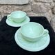 Two green opaline cup and saucer sets.