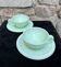Two green opaline cup and saucer sets.