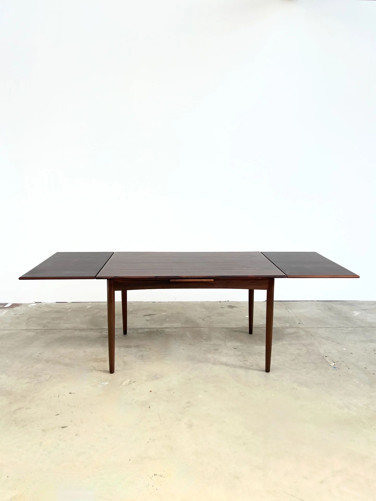 Rosewood dining table with integrated extensions — Denmark, 1960s
