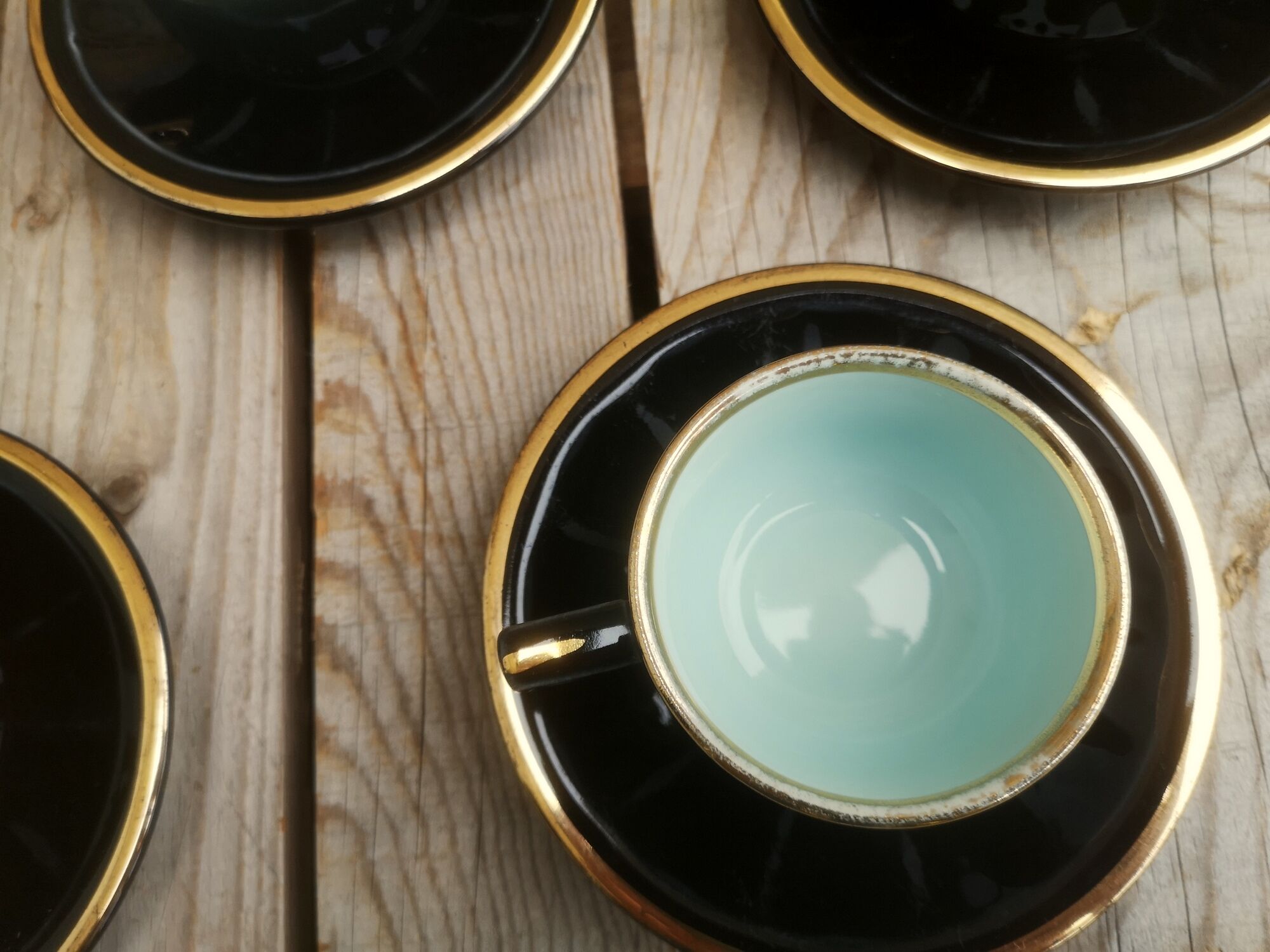 Set of 9 cups and sub-cups in black ceramic and colored gold border