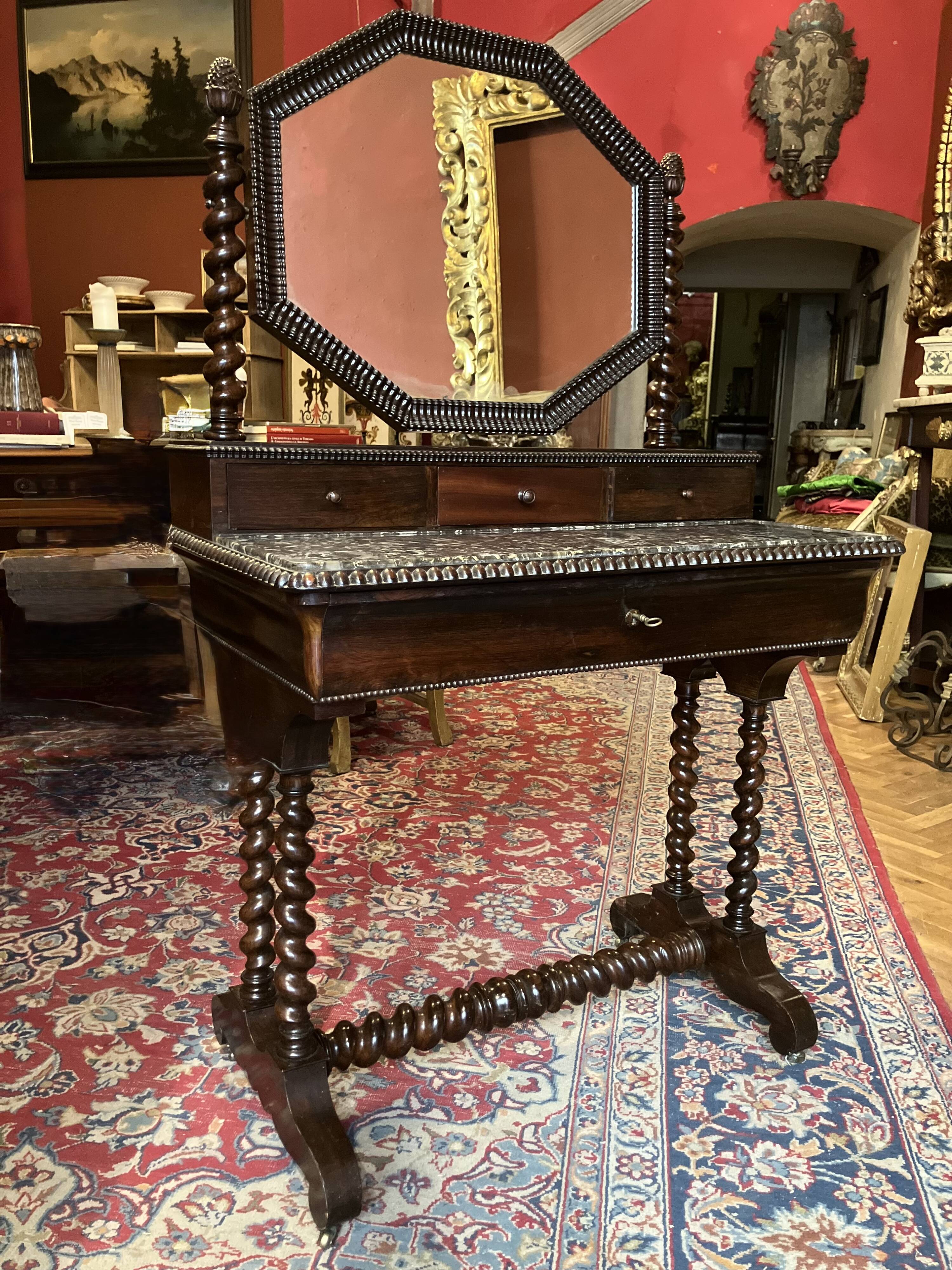 Antique English mahogany dressing table with carved details, black marble, and mirror.
