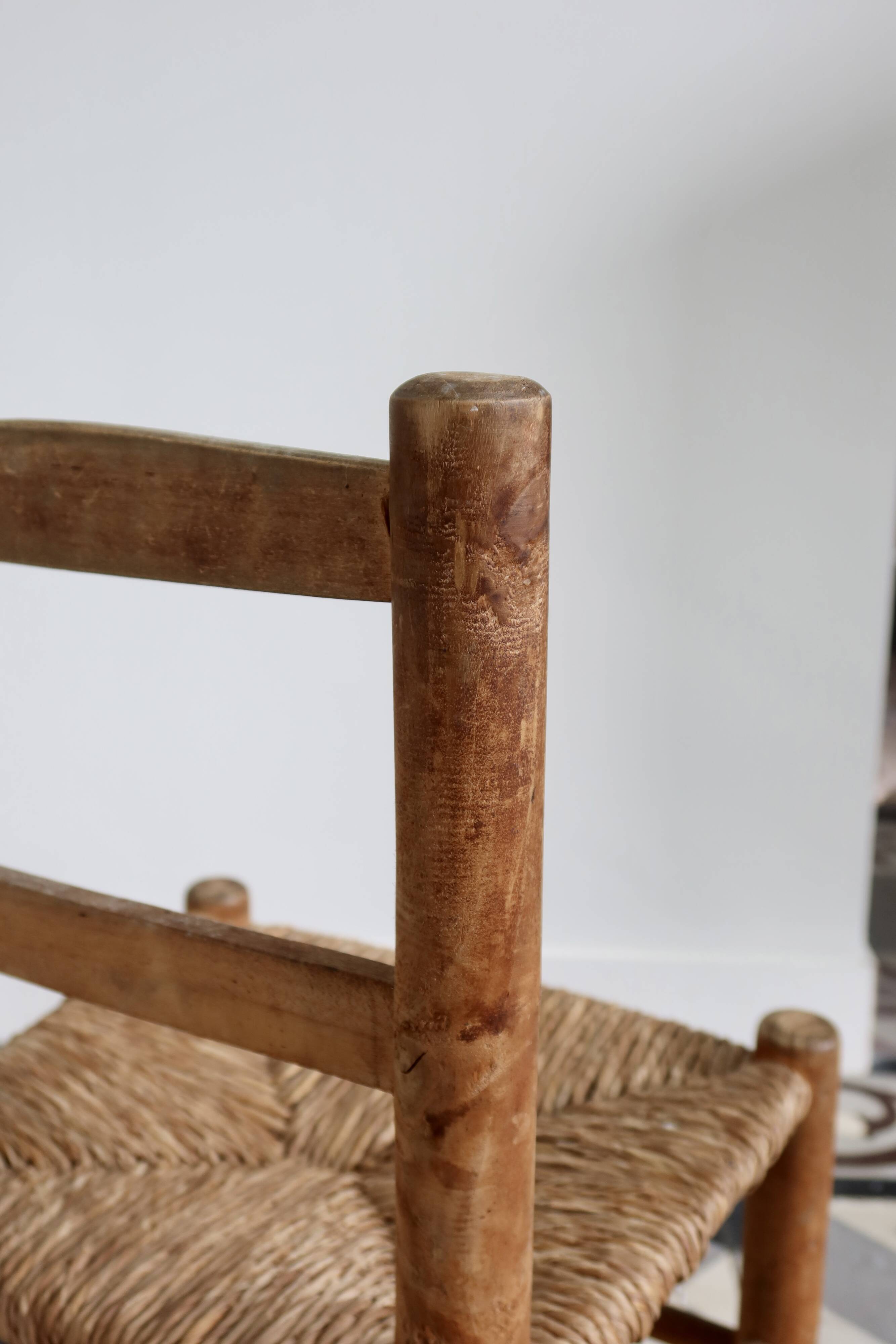 Antique wooden child's chair with a straw seat.