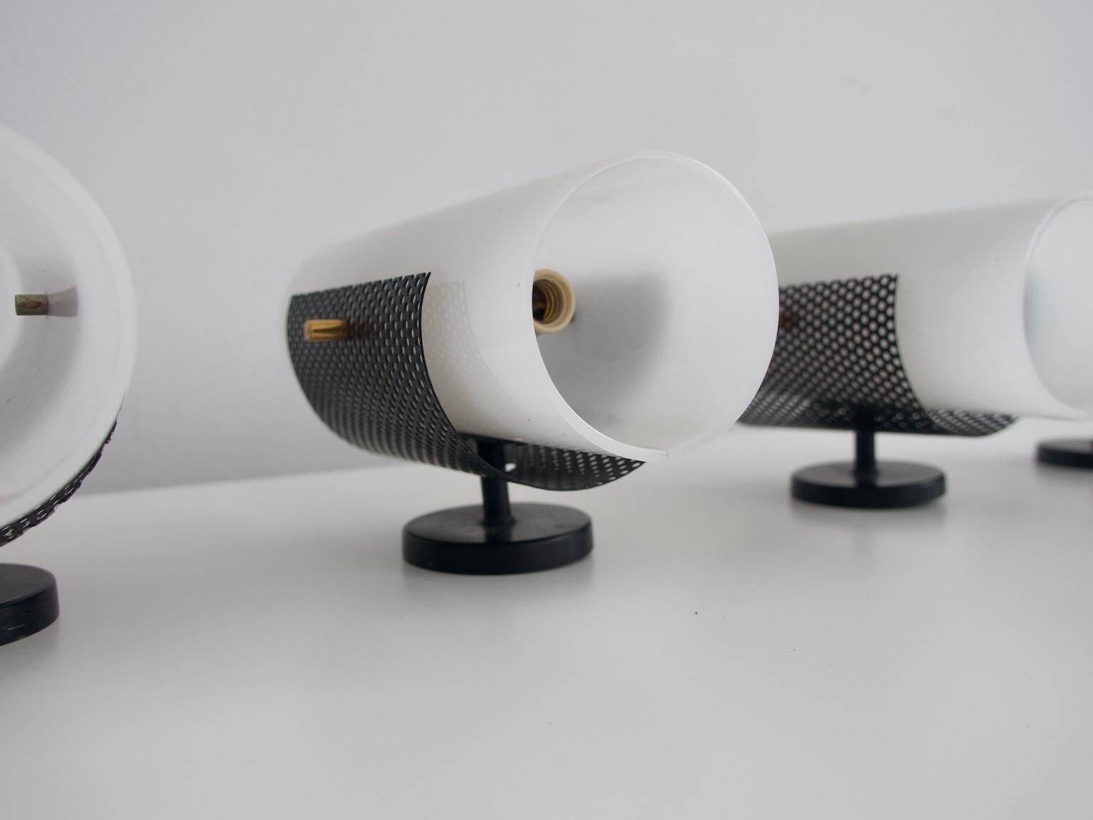Set of four wall lights in white plexiglass and perforated black metal.