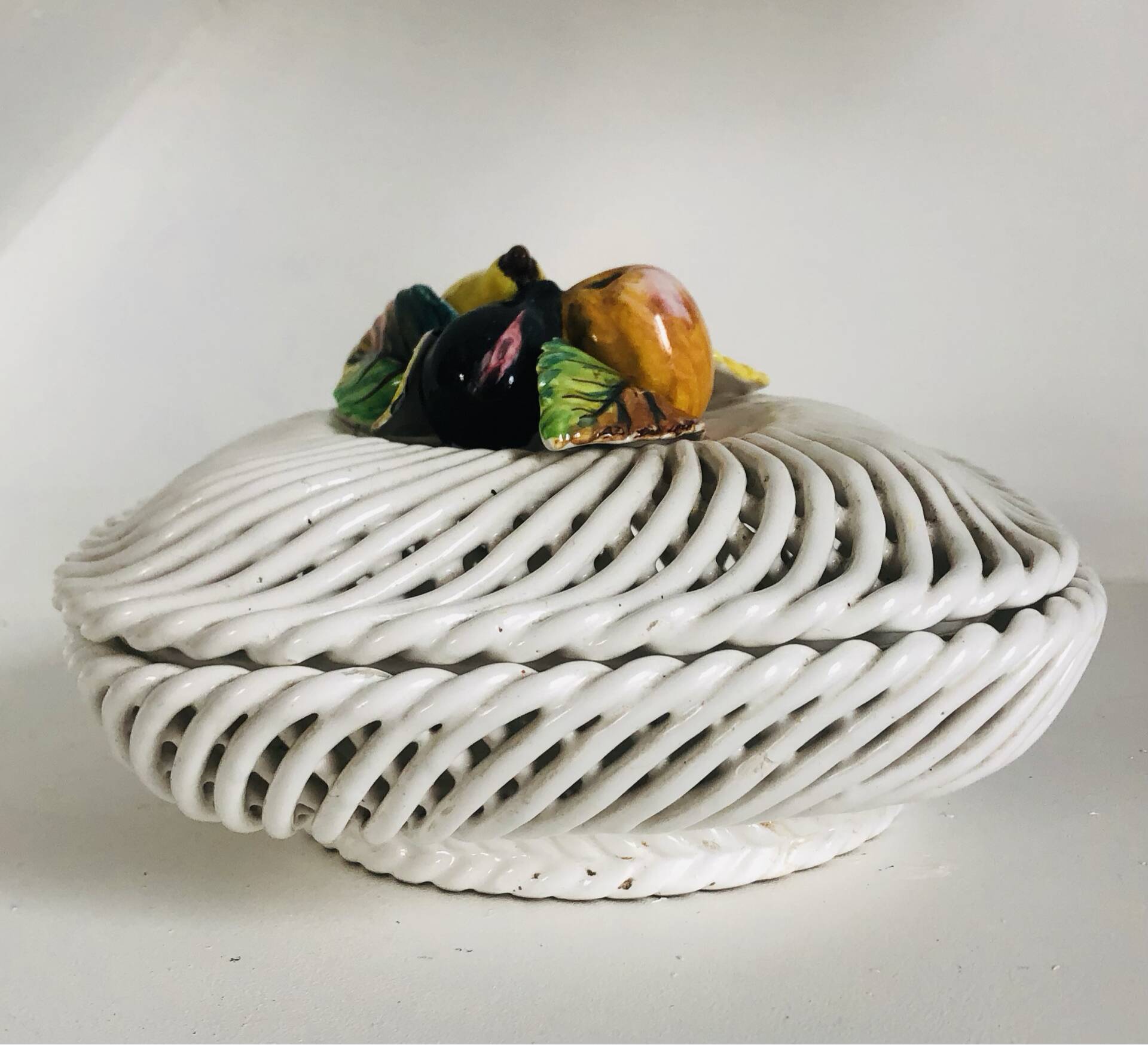Covered basket in white woven ceramic and fruit slip.