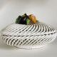 Covered basket in white woven ceramic and fruit slip.