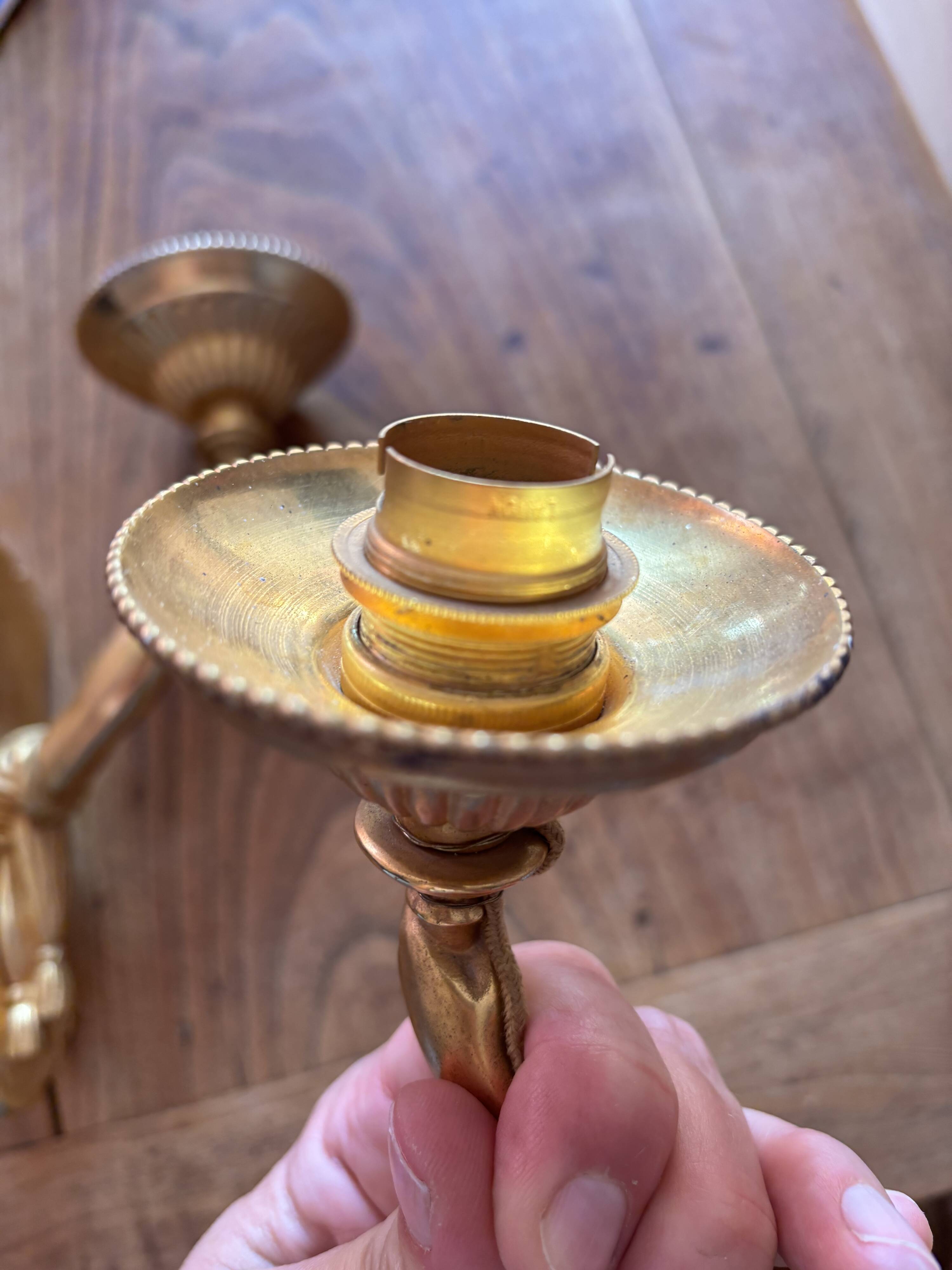 Pair of bronze wall sconces with outstretched arms and hands