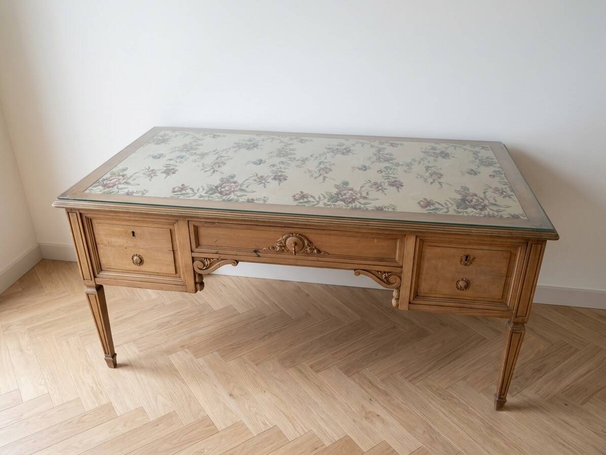 Solid wood desk with glass top and sculptures.