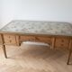 Solid wood desk with glass top and sculptures.