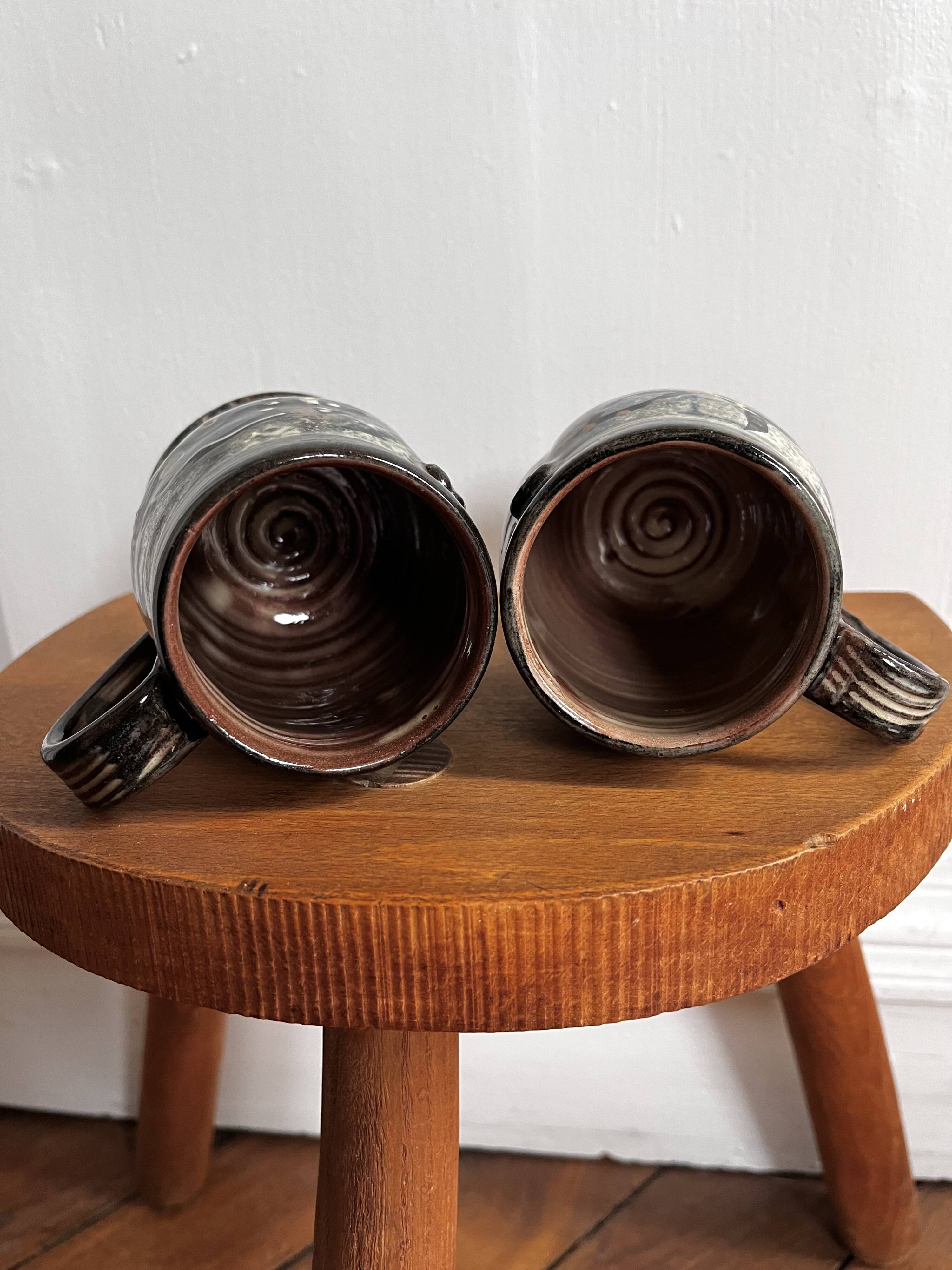 Vintage terracotta mugs with glazed designs and flower/fish motifs