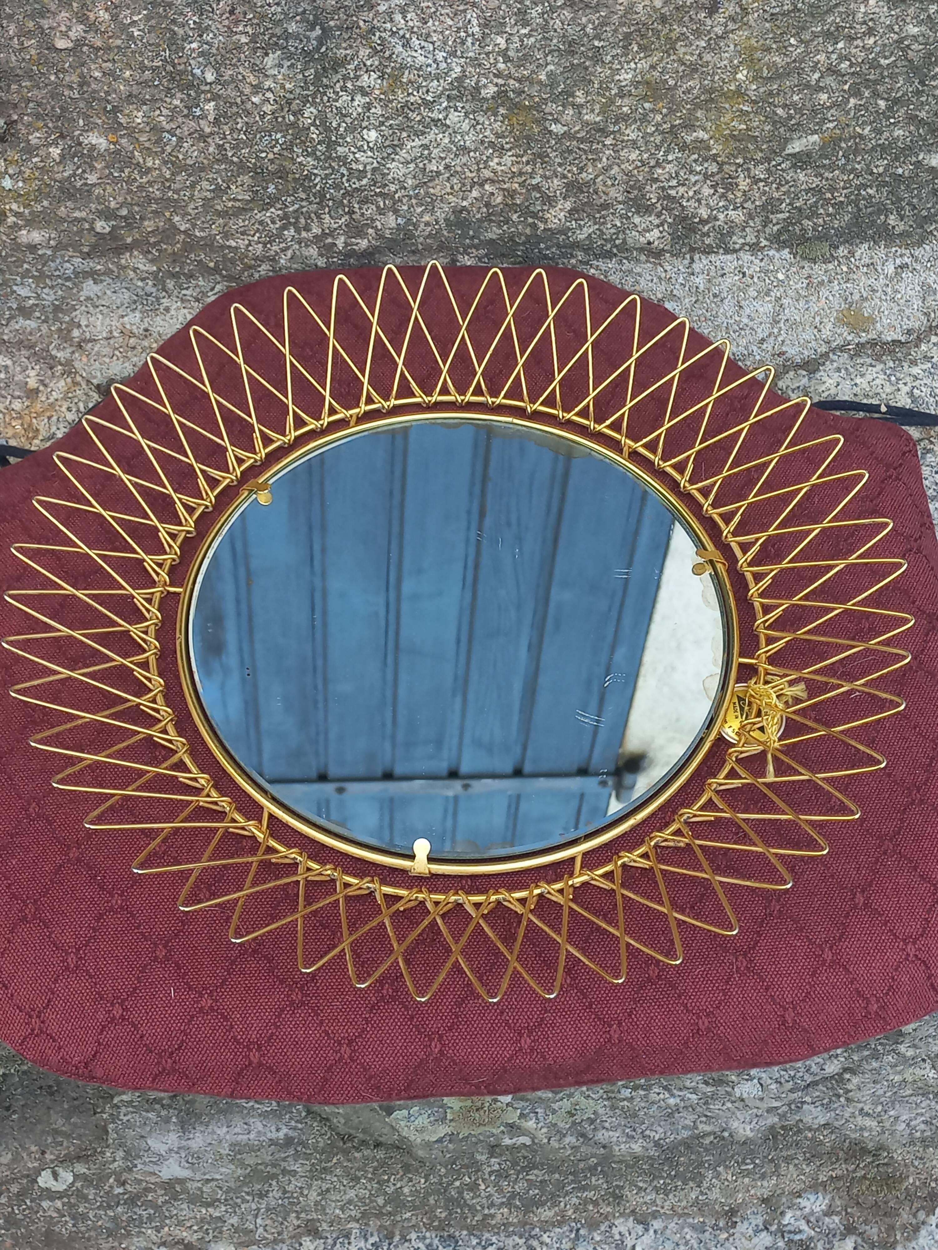 Vintage 1950s sun mirror in gold metal.