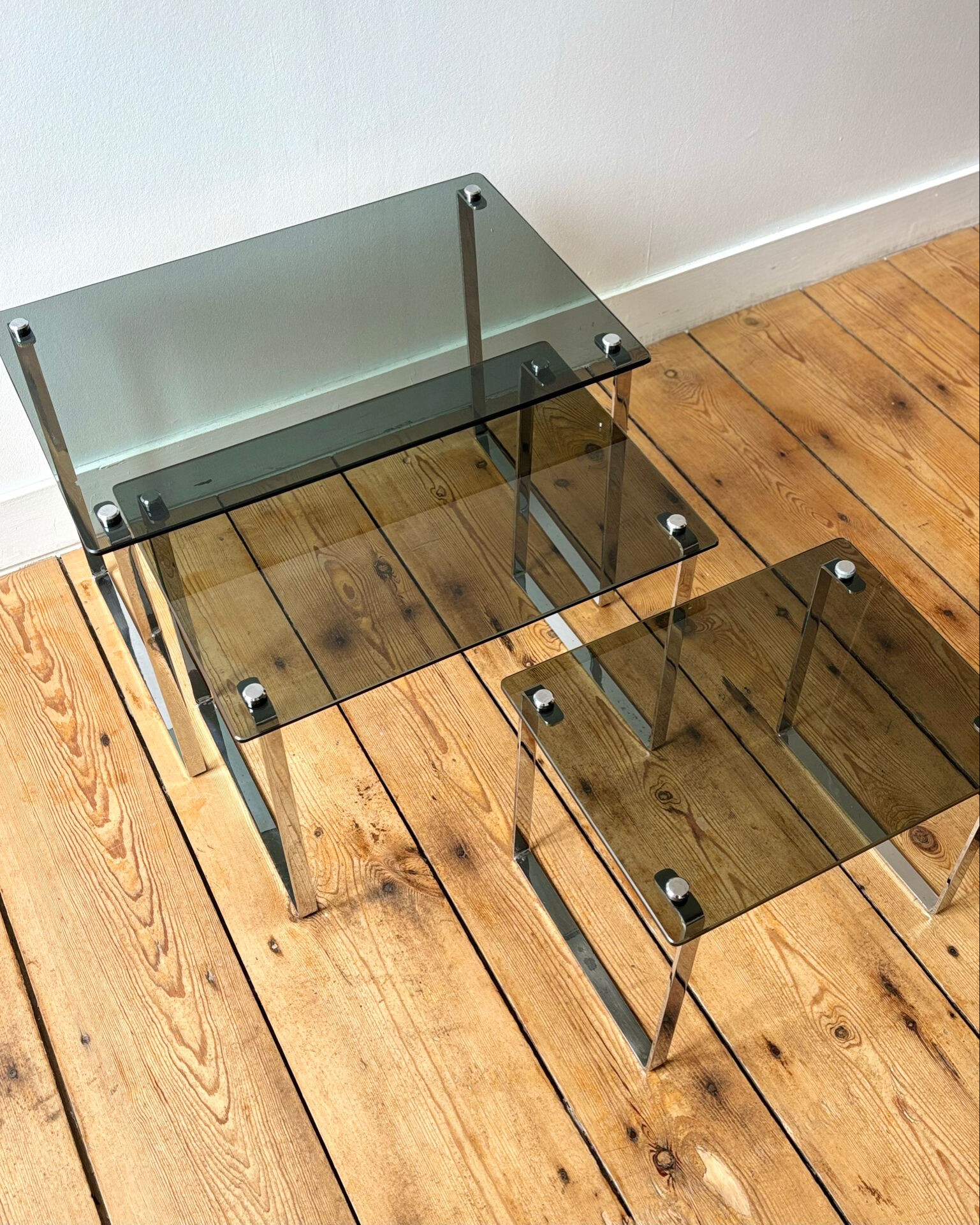 Nest of coffee tables in chrome with smoked glass top.