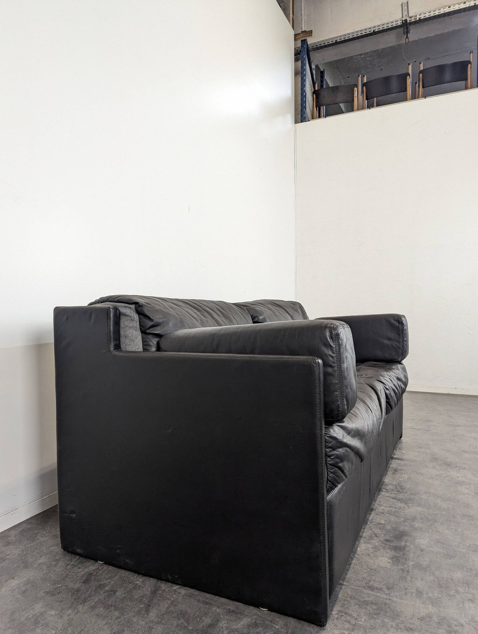Black leather convertible sofa with goose feather upholstery.