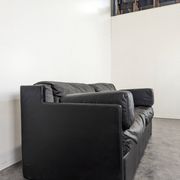 Black leather convertible sofa with goose feather upholstery.