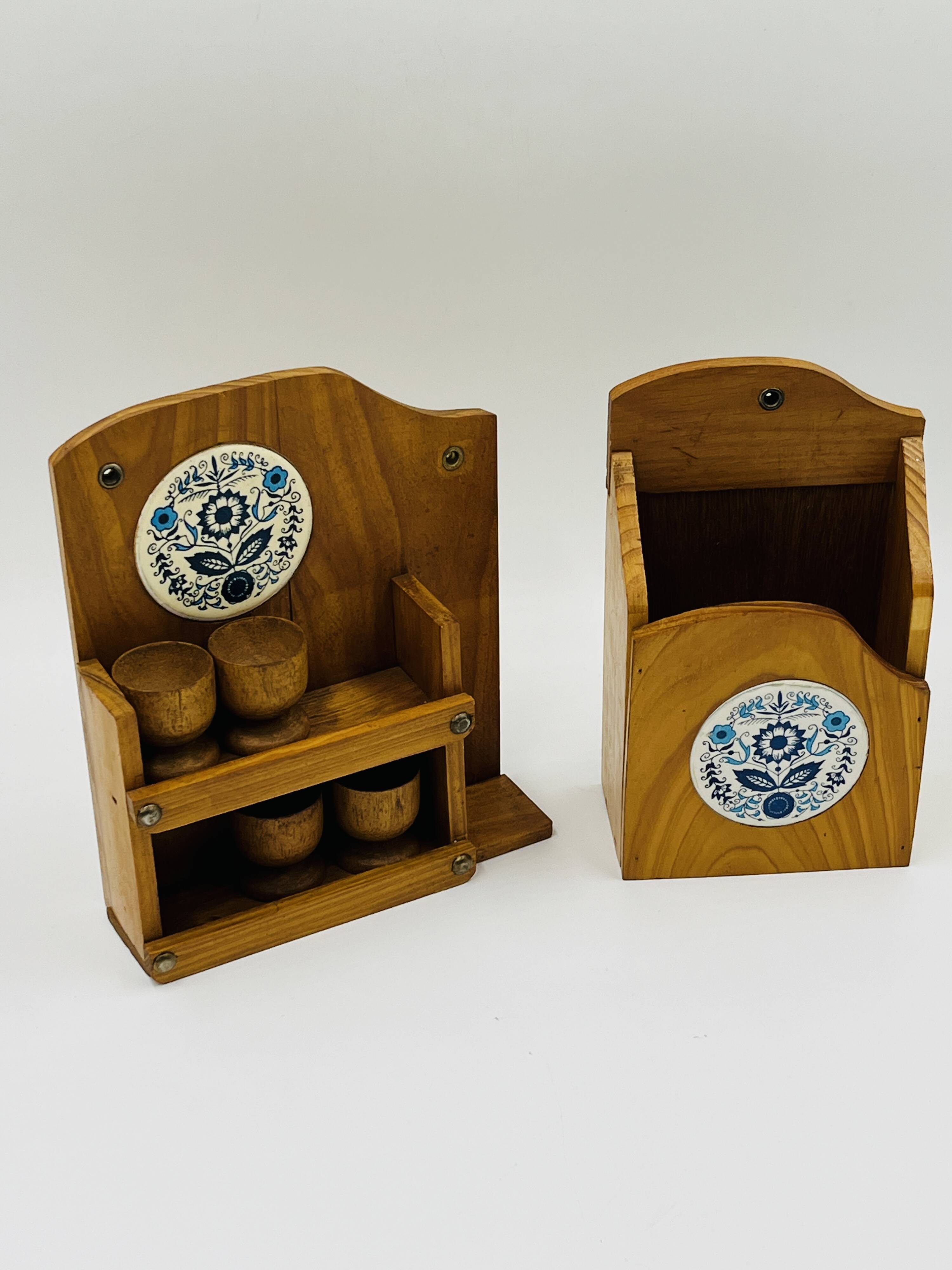 Wall-mounted egg cup holder and wooden utensil holder.