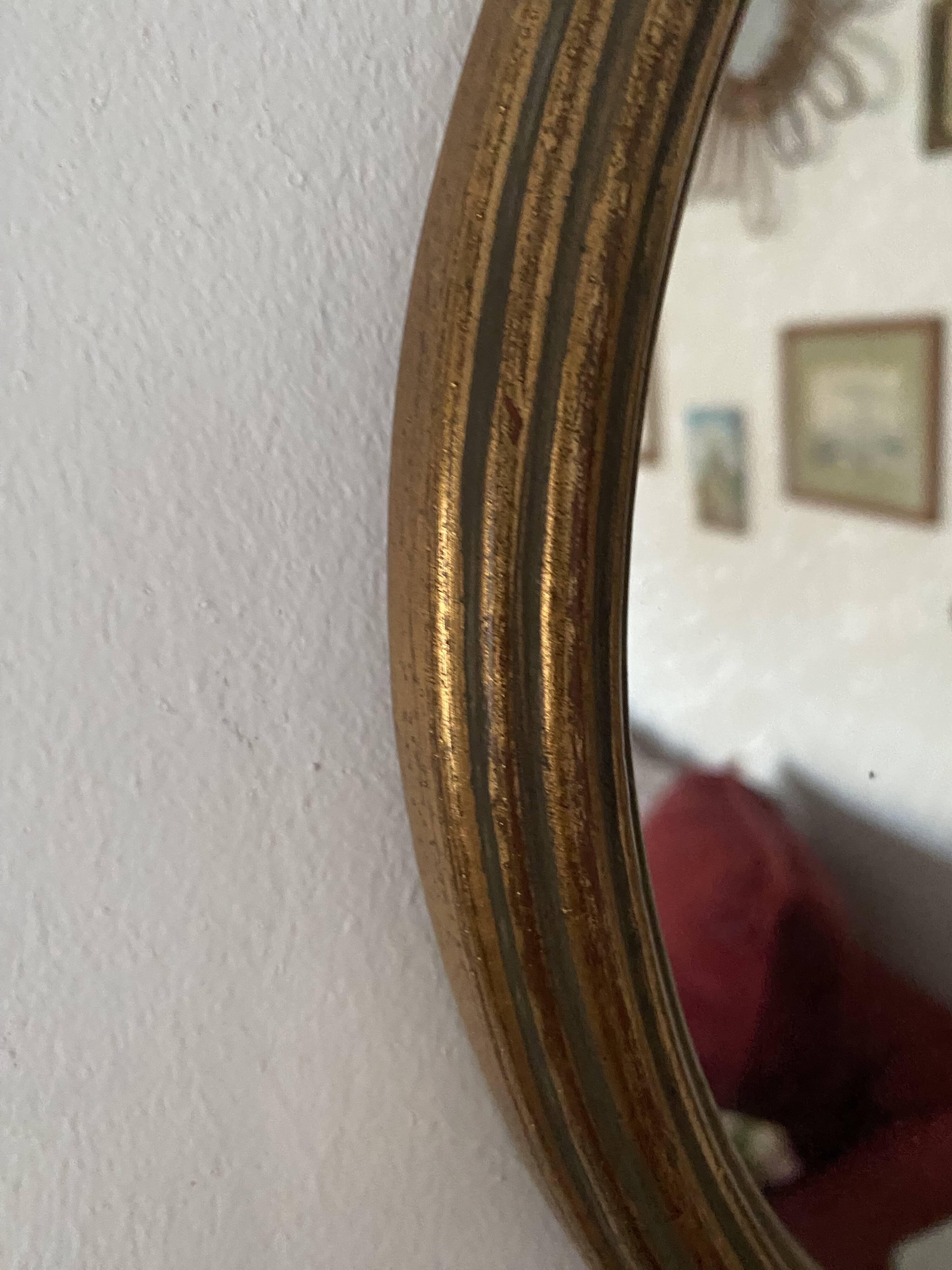 Classic oval mirror in gilded wood.