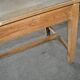 Large industrial workshop table in brown wood, wide top and sturdy vintage legs.