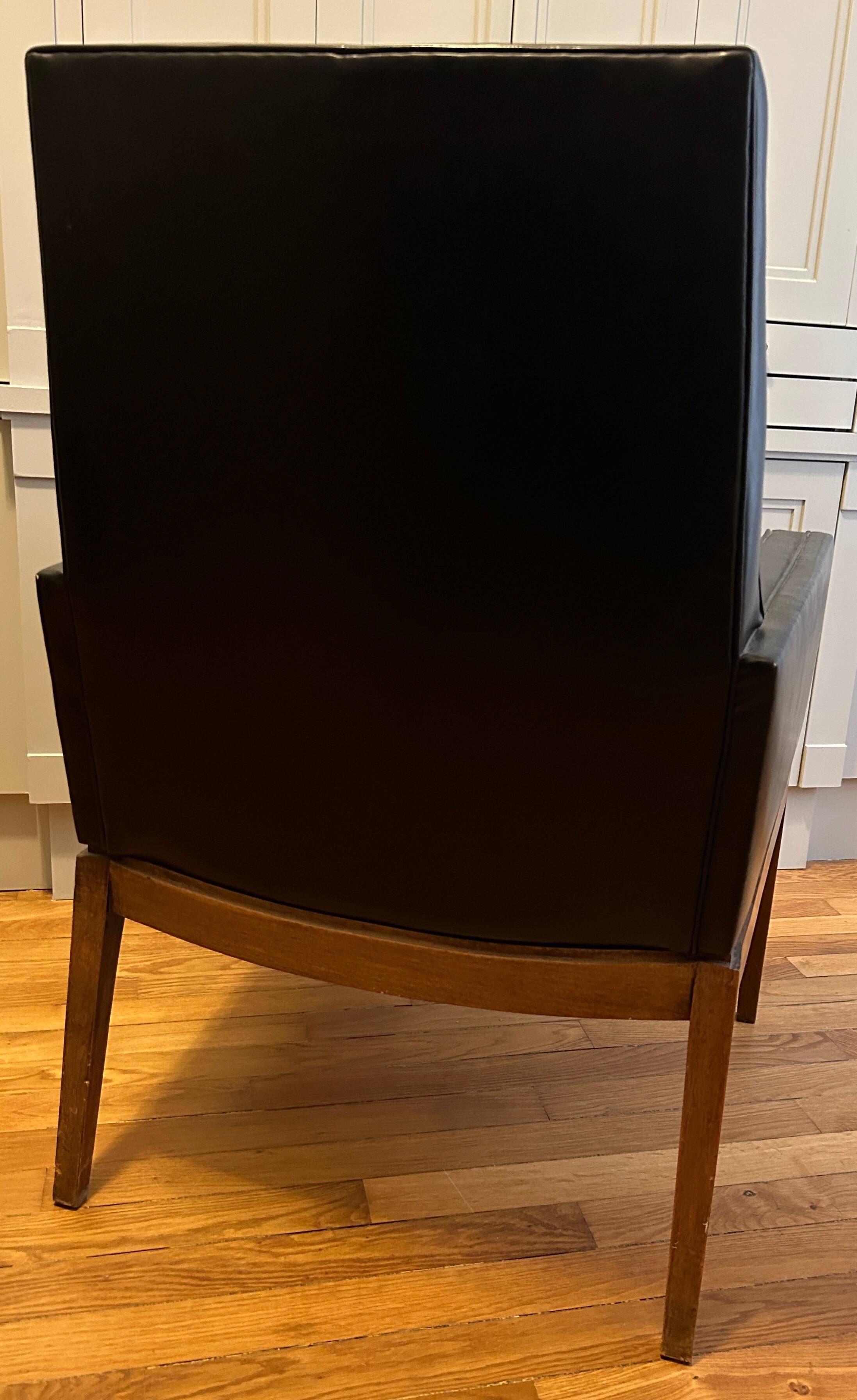 Modernist armchair in wood and black synthetic leather, circa 1960
