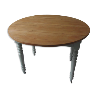 Walnut table with raised flaps, base on verdigris casters.