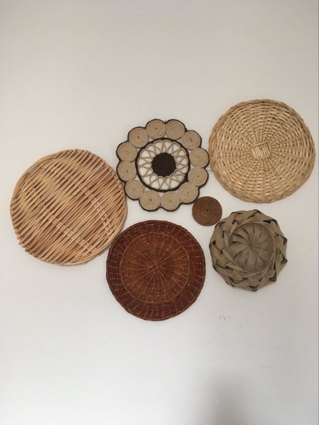 Composition murale de 6 corbeilles et plateaux en osier et corde.