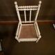 Antique wooden child's chair with turned legs and caning, white patina.