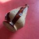 Large antique pottery bottle in glazed terracotta with drips.