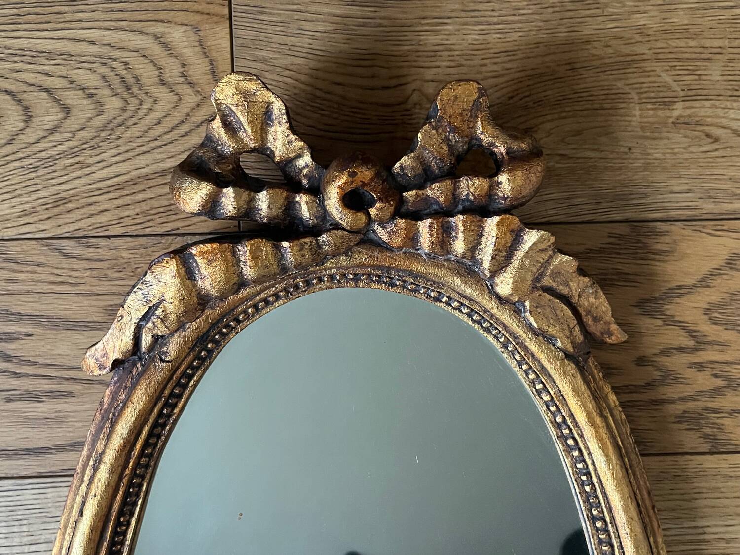 Old oval gilded stucco mirror