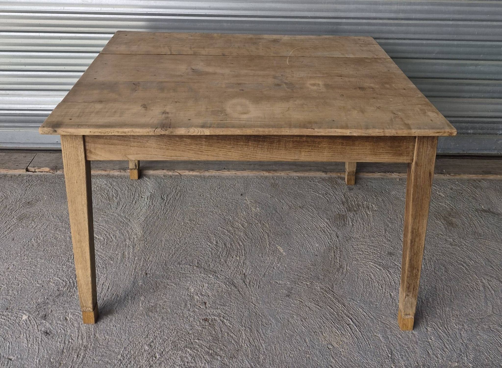 Old farmhouse table with its 2 extensions and raised legs.