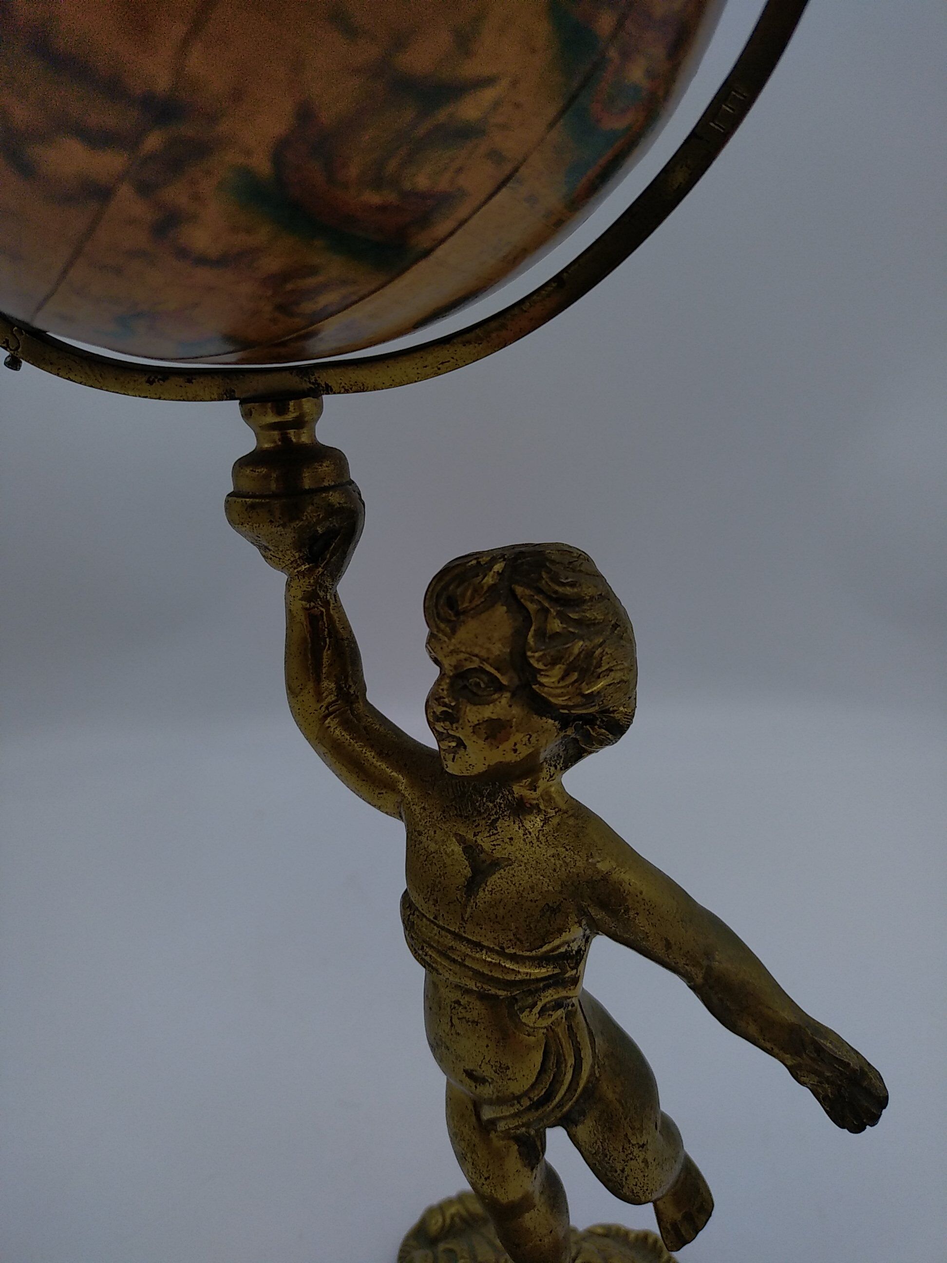 Cherub or putti carrying a globe