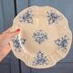 Old Gien plate with carved edges featuring doves and blue flowers, circa 1920-1930.