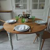 Walnut table with raised flaps, base on verdigris casters.