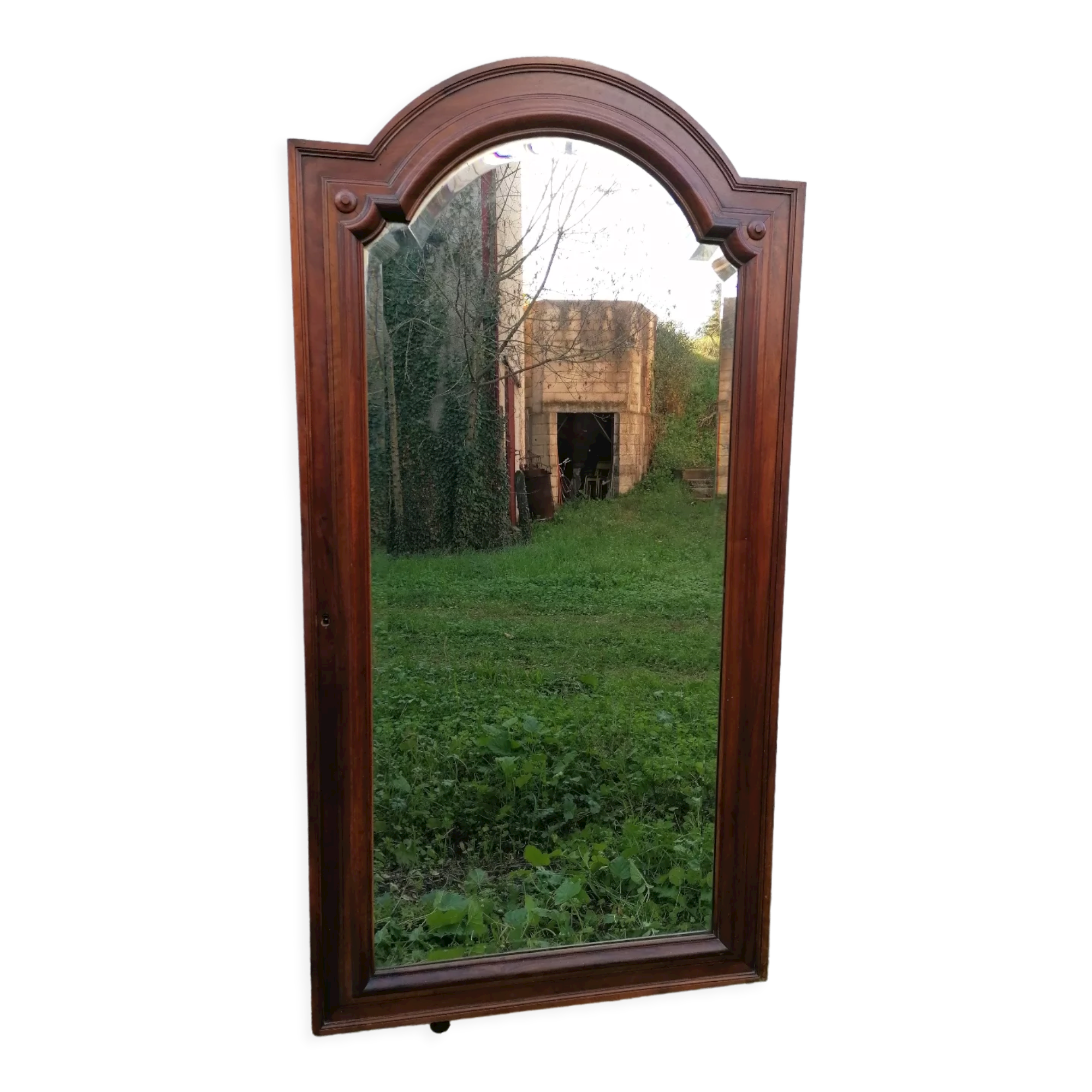 Old beveled solid wood mirror of a cabinet door.
