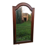 Old beveled solid wood mirror of a cabinet door.