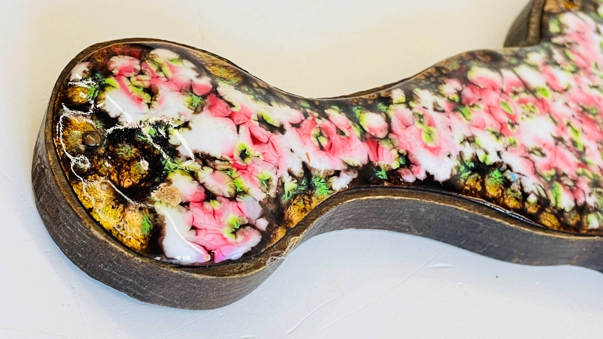 Vintage enameled metal hand mirror on wood