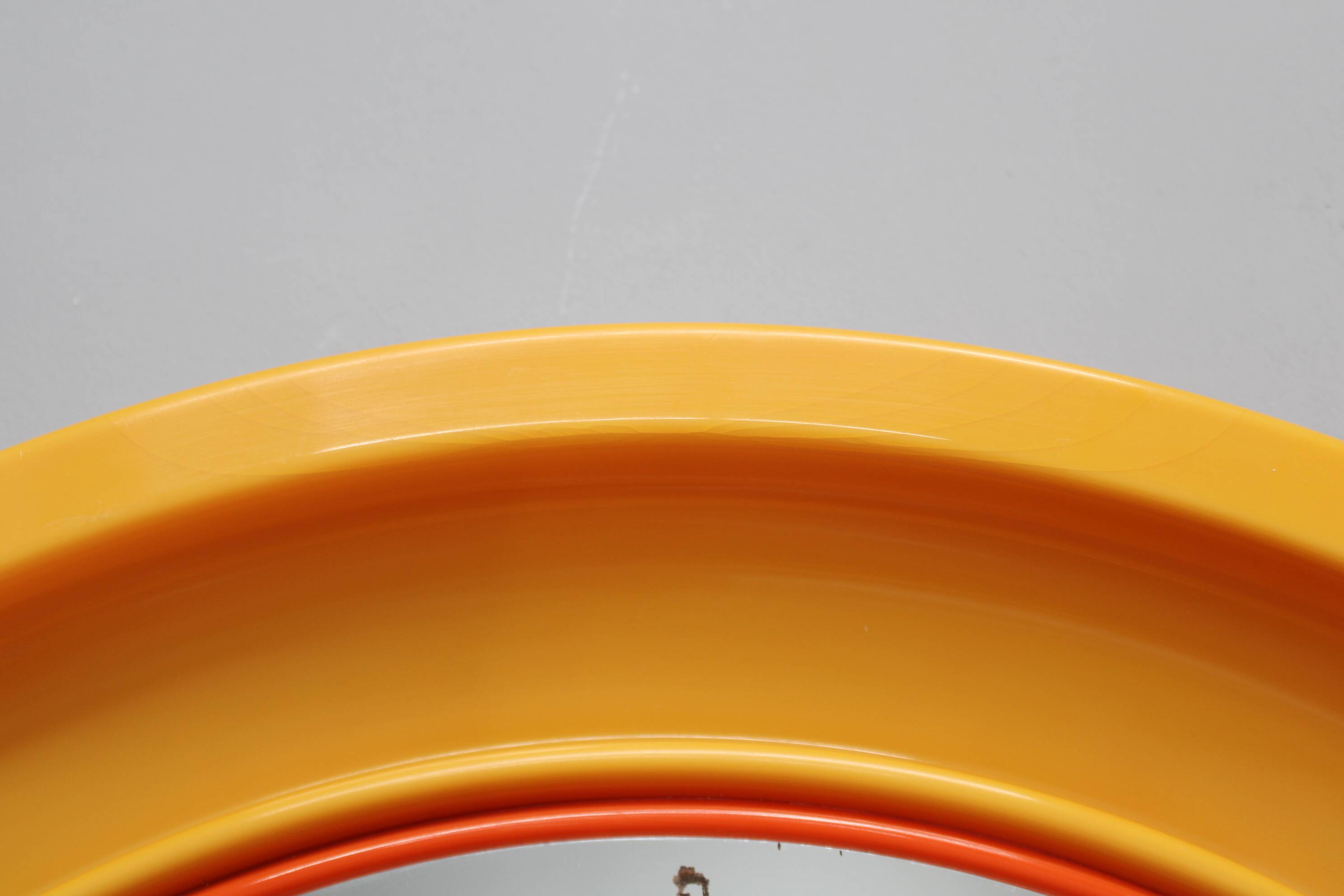 Miroir rond italien des années 1970 de la marque Salc, avec cadre en plastique jaune orangé.